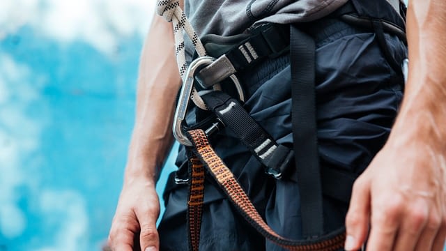 Close-up of climber wearing safety harness and climbing equipment